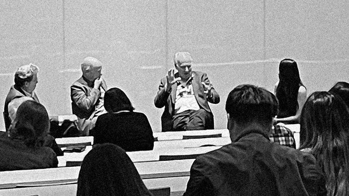 panel of four speakers at a campus event with audience members in foreground