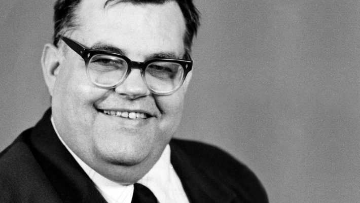 A man in a suit smiles for a photo