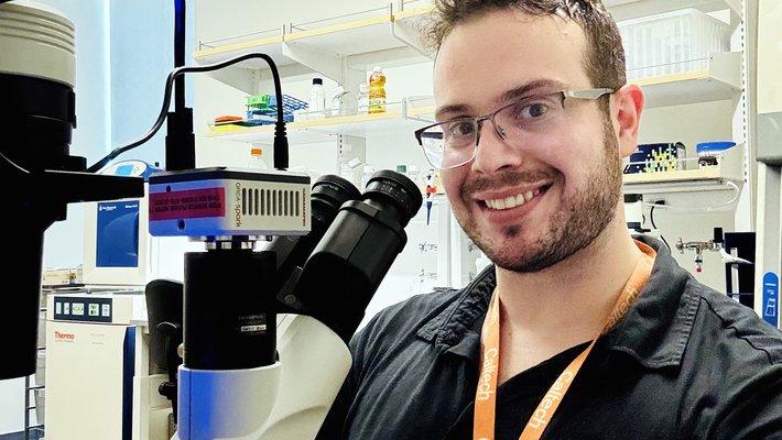 Matheus de Castro Fonseca seated at a microscope