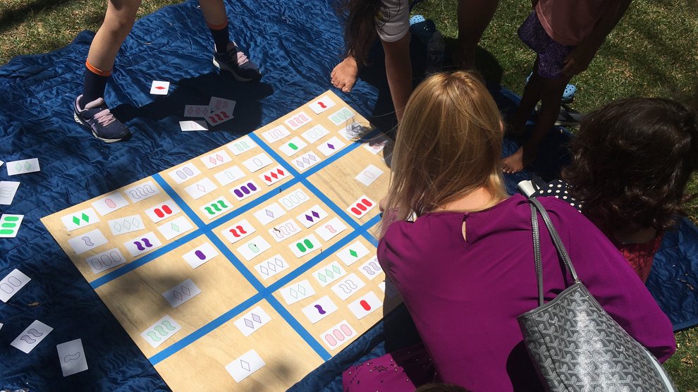 Families collaborated on a challenging variation of the game SET in which players create a quilt of mathematical patterns.
