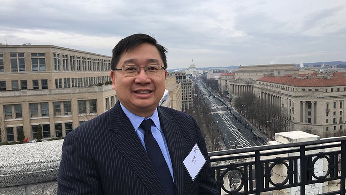 Photo of Caltech Alumnus Thomas Luke with Washington, D.C. in the background.