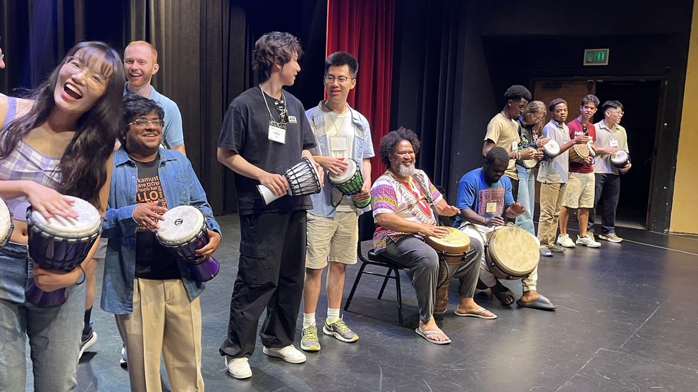 Danny Petersen leads international students in a drum circle at an orientation welcoming event