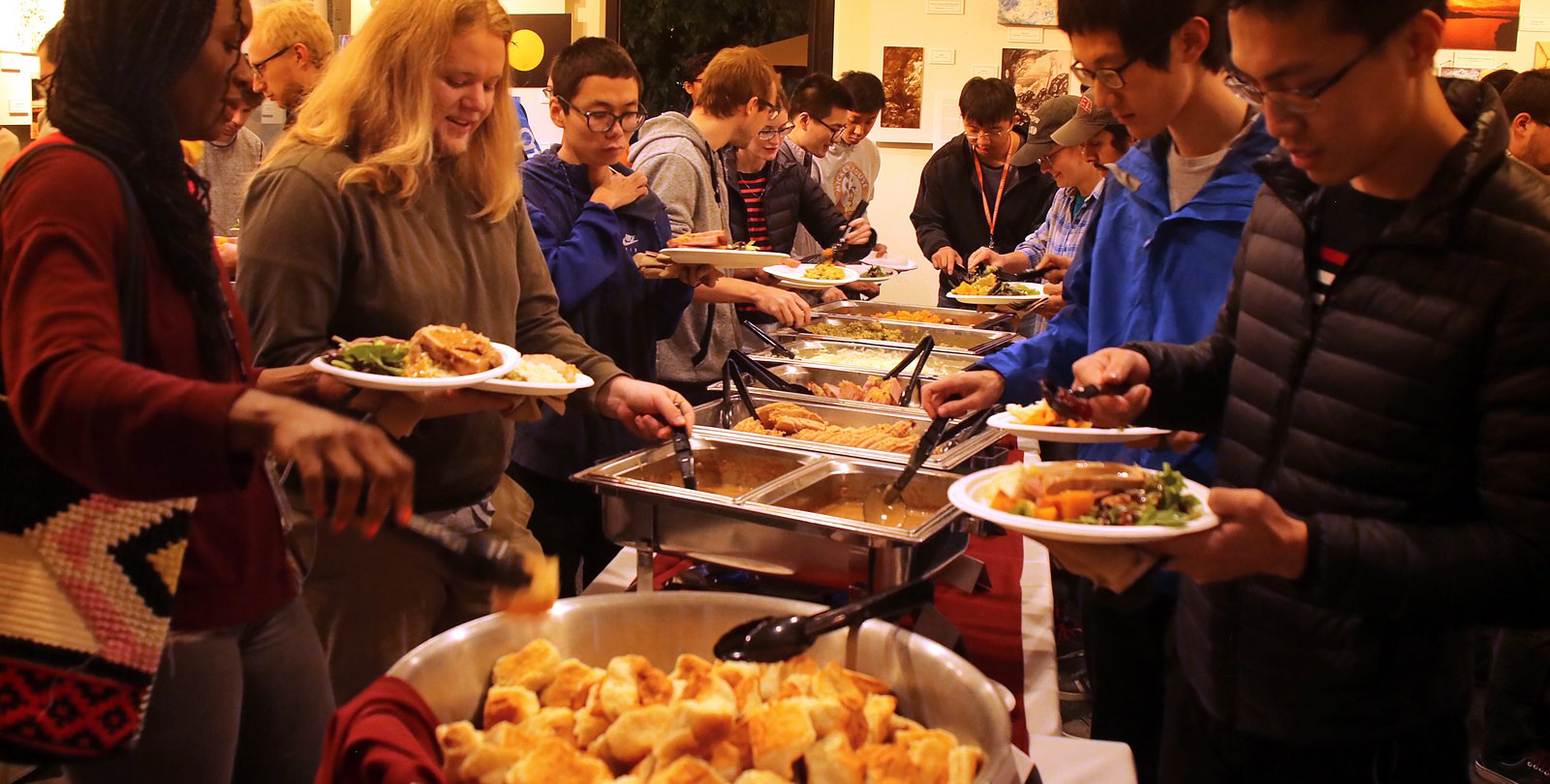 Postdocs and grad students line up to scoop traditional Thanksgiving dishes onto plates