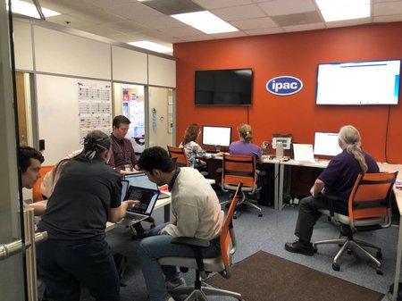 People huddled around computers in the IPAC operations center for Lunar Trailblazer.