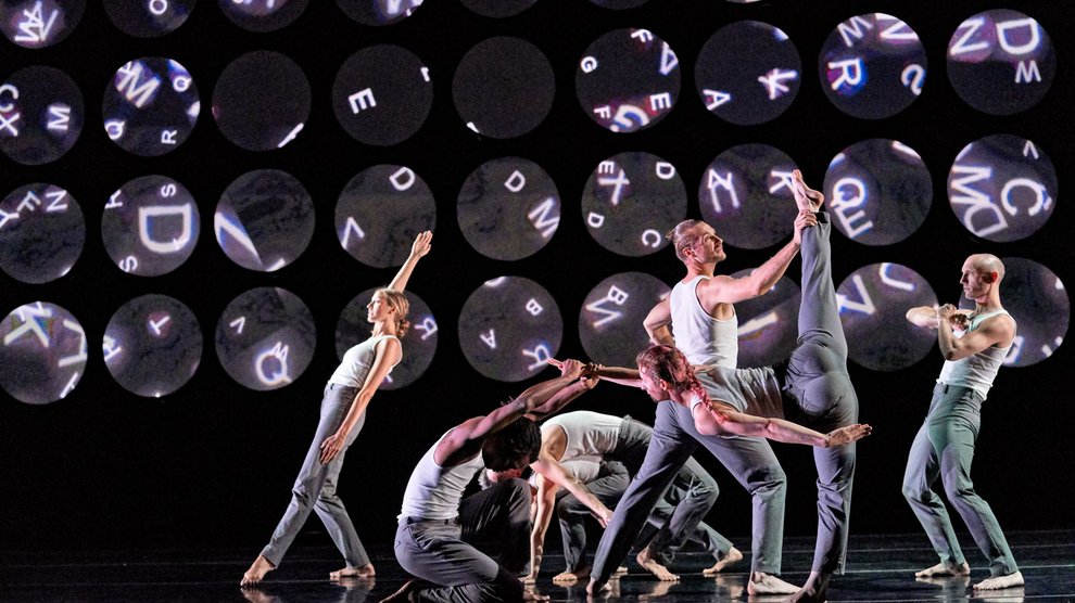 A group of dancers in a formation on stage