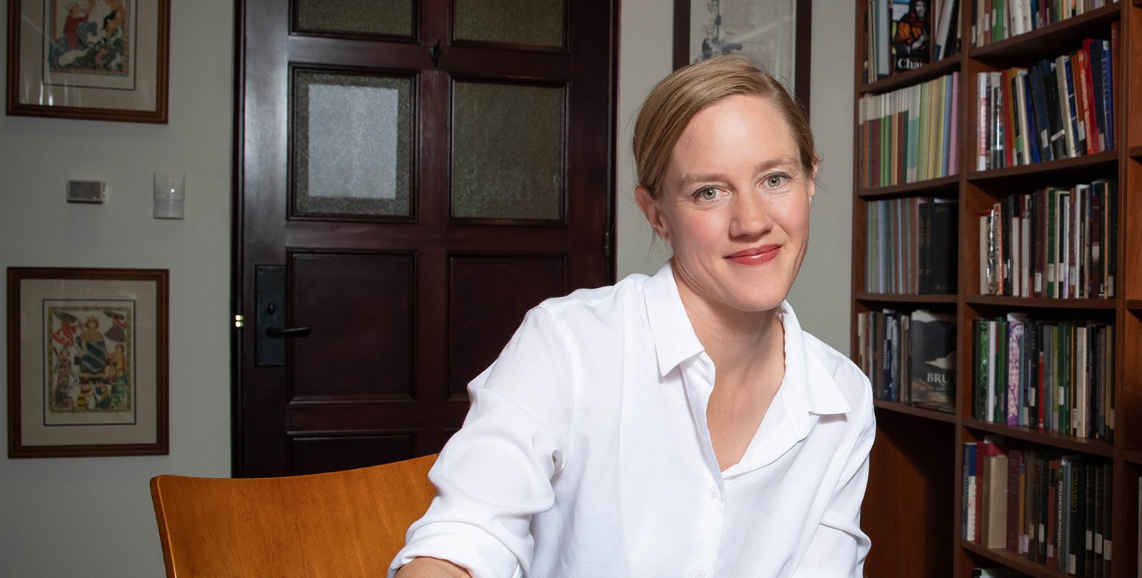 Portrait of new dean of Jennifer Jahner wearing a white shirt in front of a bookshelf