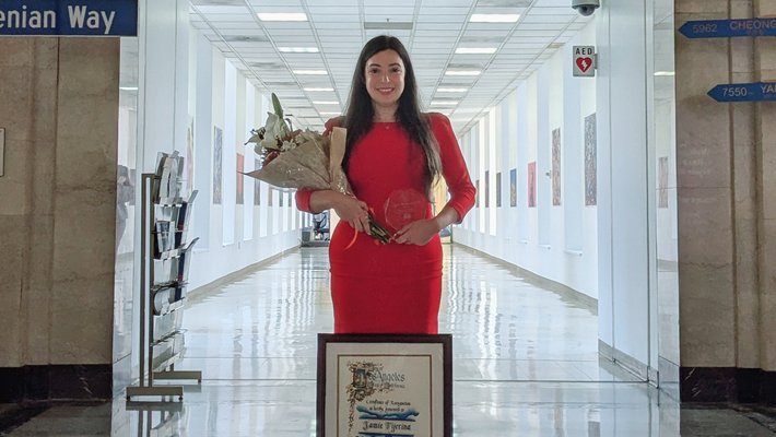 Jamie Tijerina wearing red dress and displaying plaque at LA City Hall