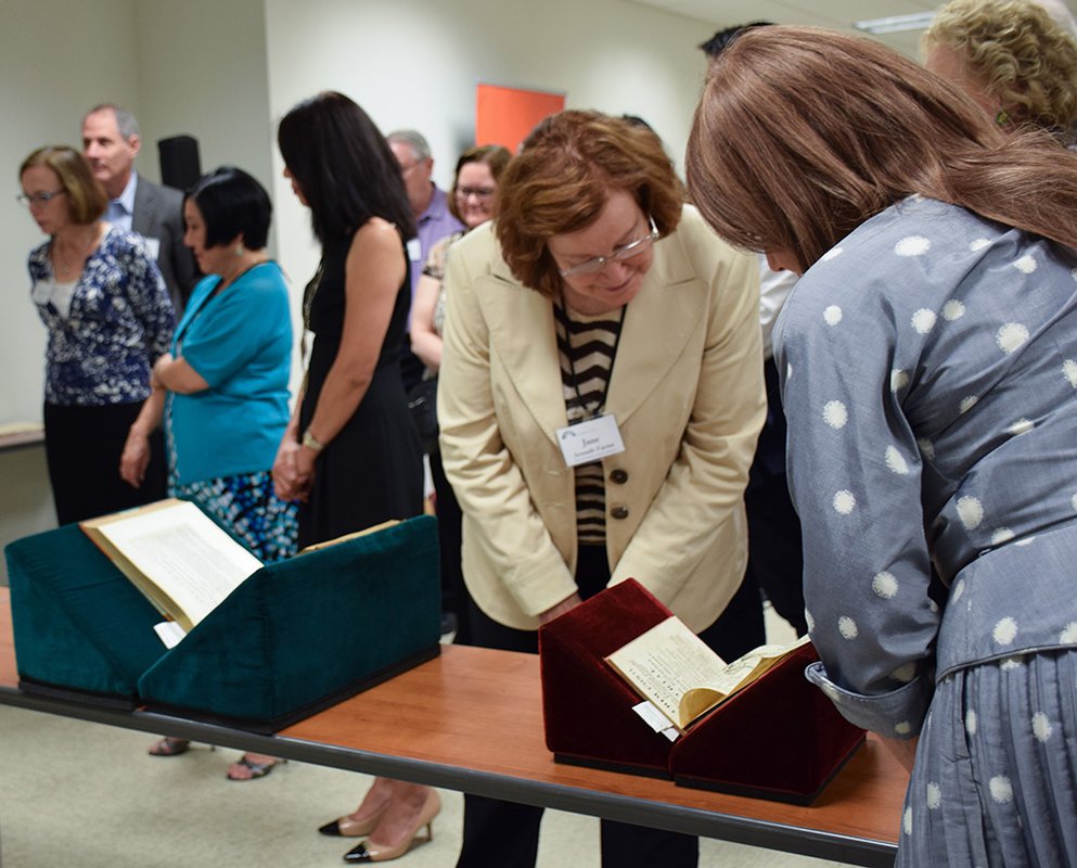 photo of people perusing some of The Huntington's materials from the time period in which Austen's novels were set.