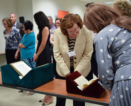 photo of people perusing some of The Huntington's materials from the time period in which Austen's novels were set.