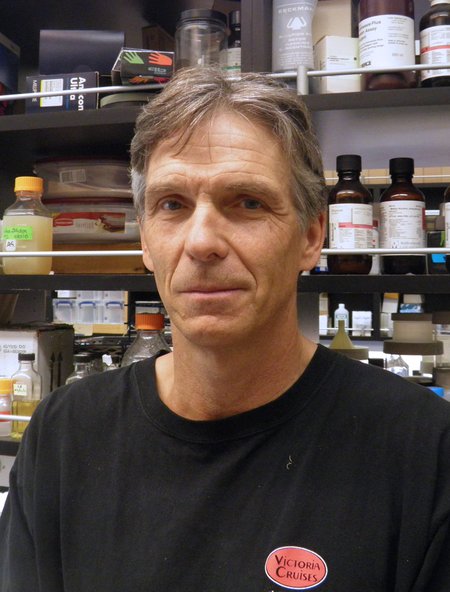 A person smiles for a photo in a laboratory