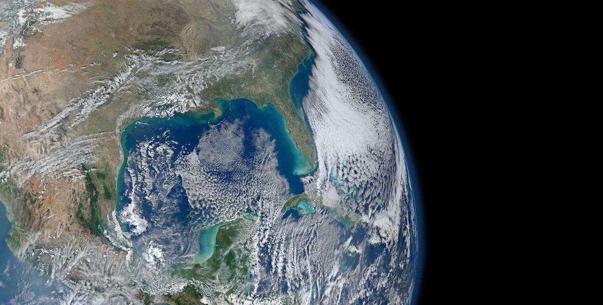 An image of Earth from orbit. Blue ocean and swirling white clouds are seen.