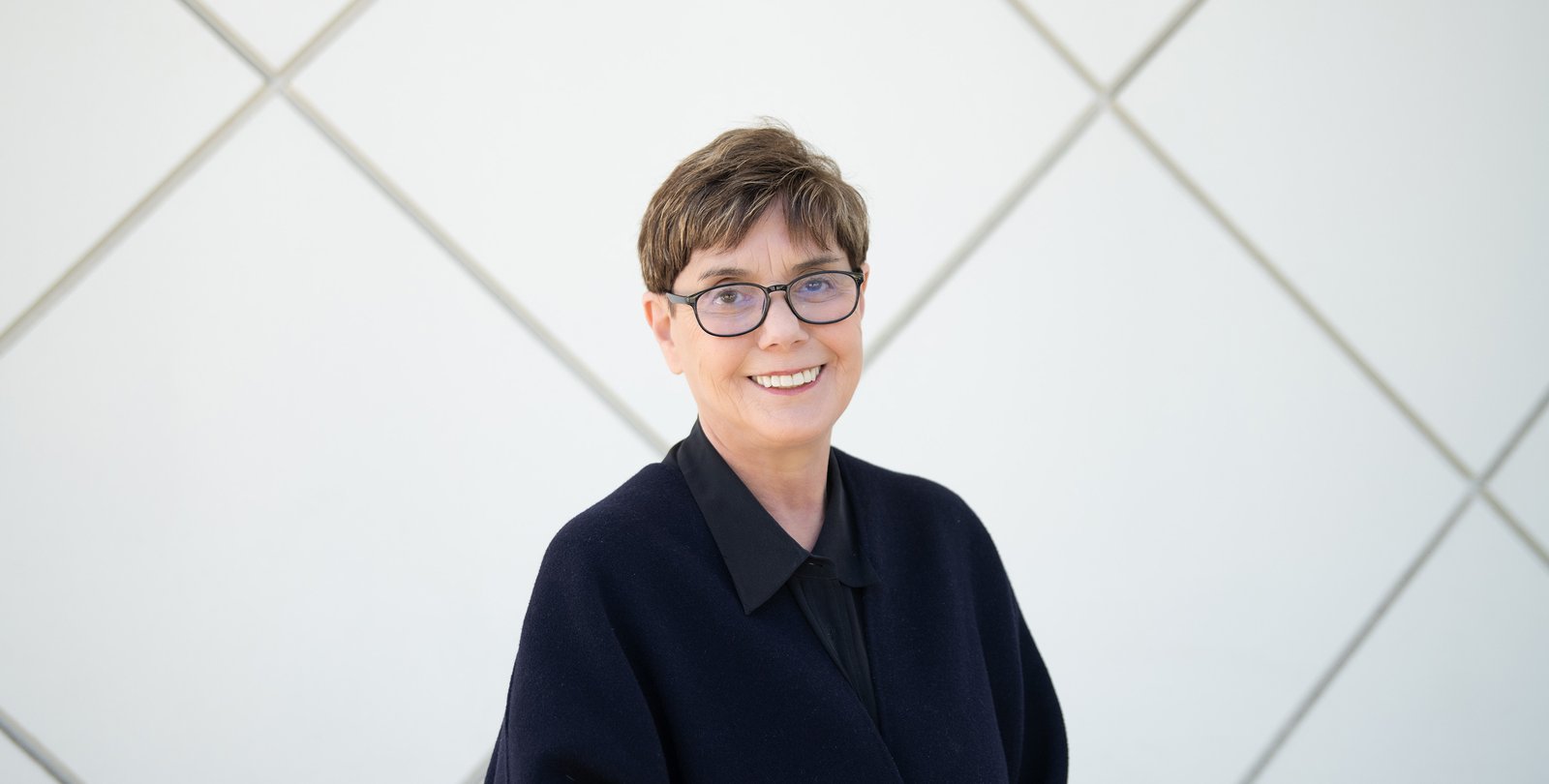 Image of Diana K. Buchwald wearing a black top in front of Beckman Auditorium