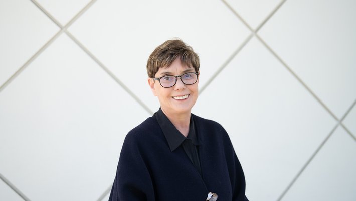 Image of Diana K. Buchwald wearing a black top in front of Beckman Auditorium