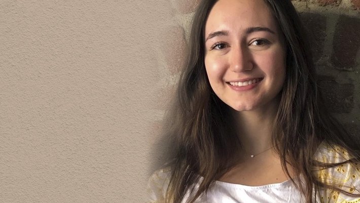 A woman with brown hair smiles for a photo