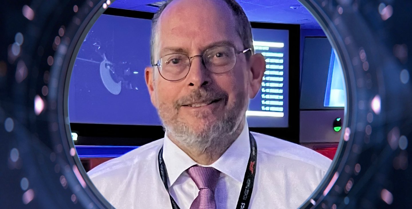 A person with a tie smiles for a photo