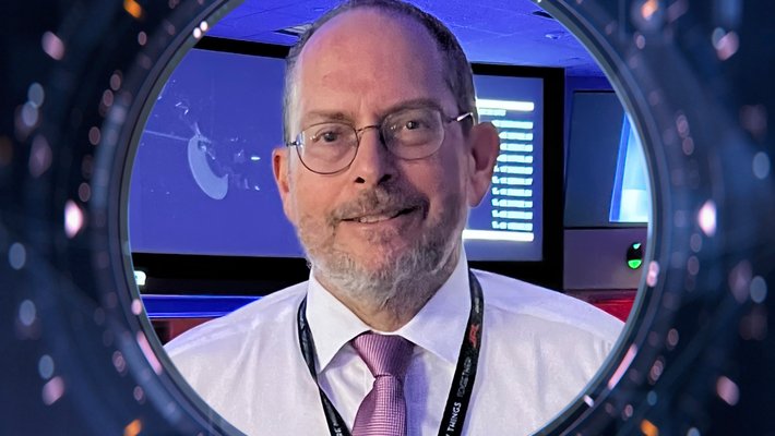 A person with a tie smiles for a photo