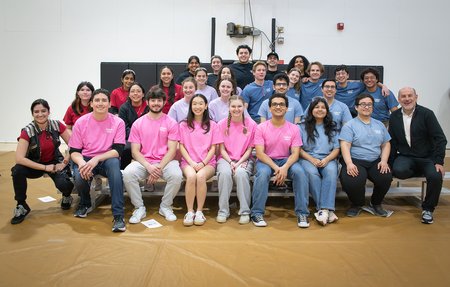 Five teams of students and an instructor sit on the bleachers following the ME72 competition.