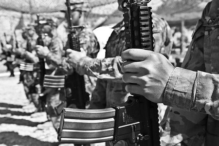 A black-and-white photo of soldiers standing in a row, holding their weapons