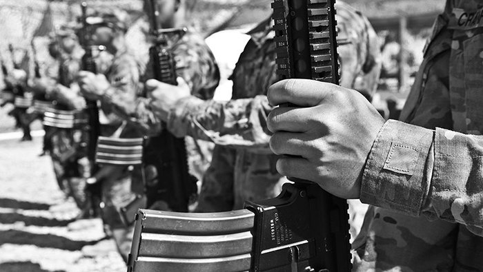 A black-and-white photo of soldiers standing in a row, holding their weapons