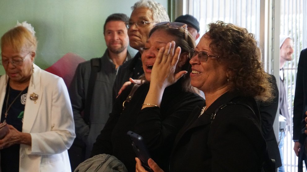 Michelle Ellington, center, has an emotional reaction to seeing the portrait of her grandfather for the first time. To her right is Erzel Thomas, a member of the Scott-Venerable family.