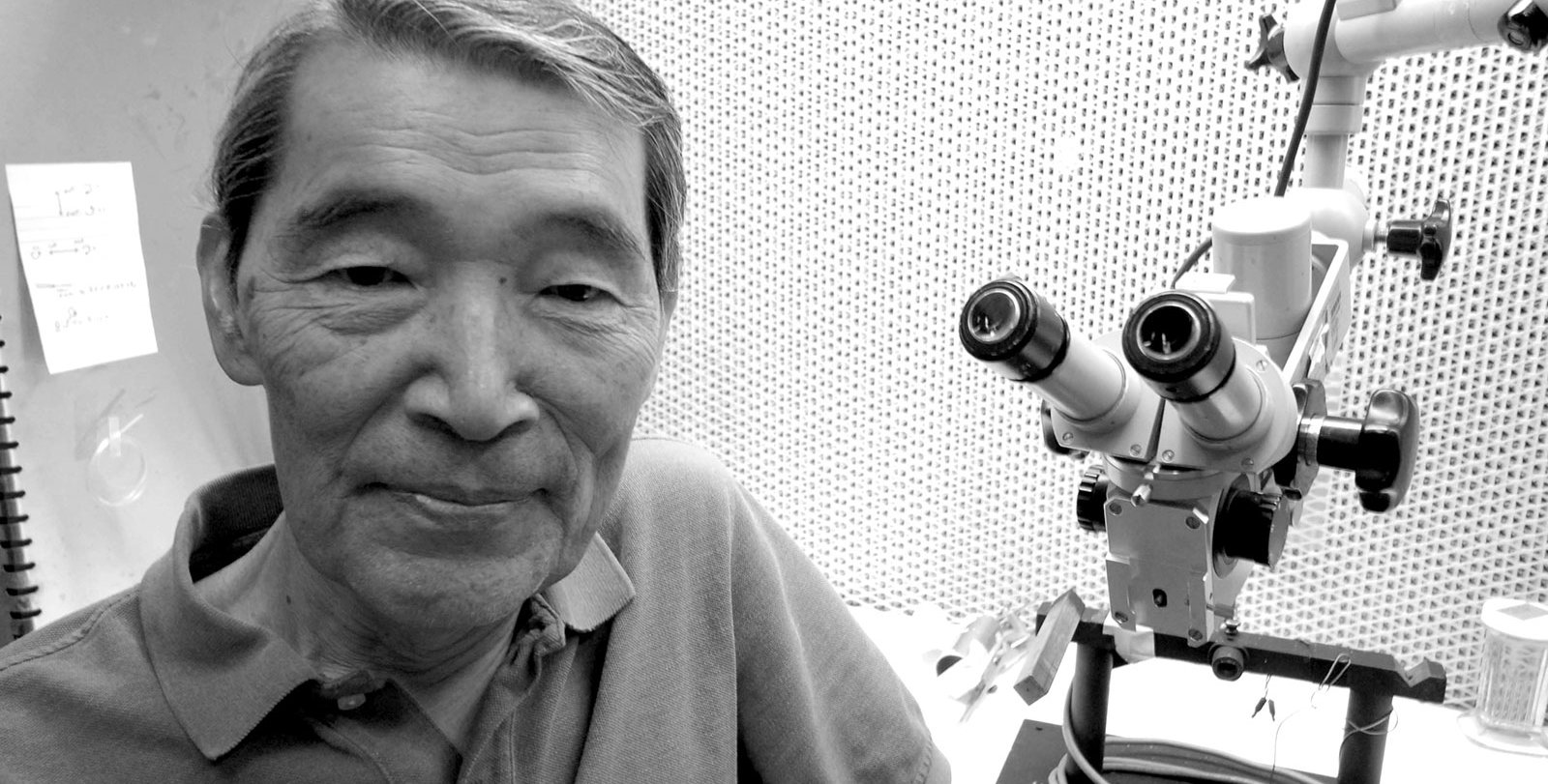 Masakazu (Mark) Konishi next to a microscope