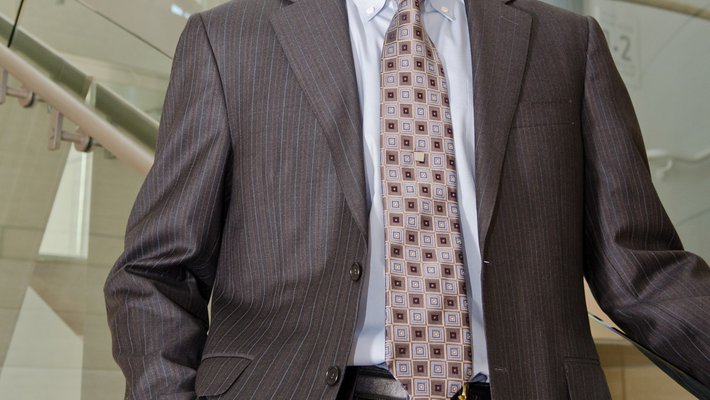 A man in a suit smiles for a photo