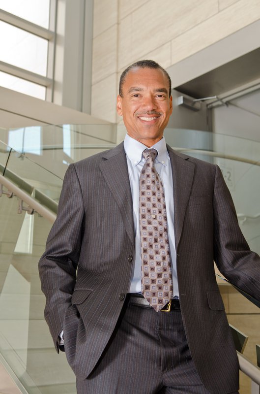 A man in a suit smiles for a photo
