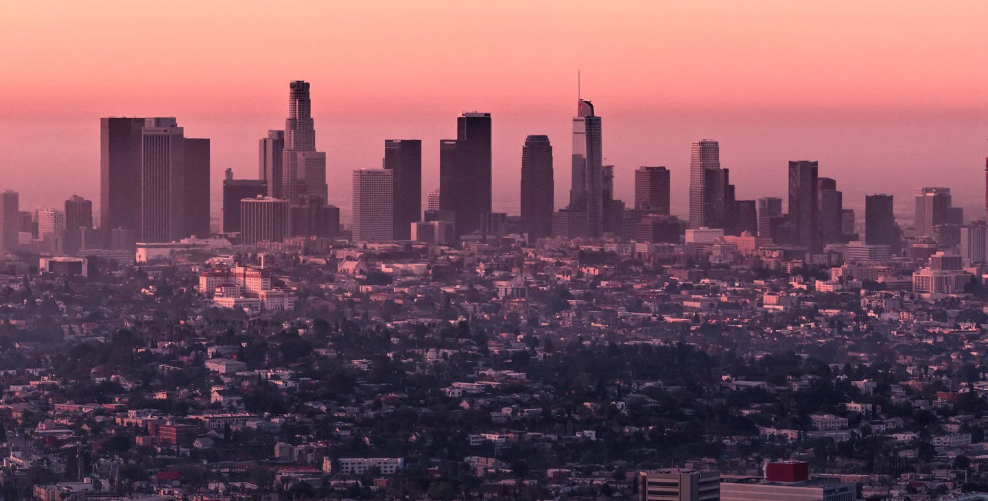 A photo showing the Los Angeles skyline near sunset. The air is hazy.