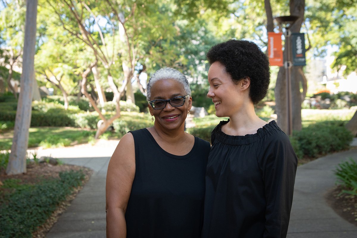 A portrait of Dana Murphy and her mom, Marta Murphy. Marta Murphy looks at the camera. Dana looks at her mom and smiles.