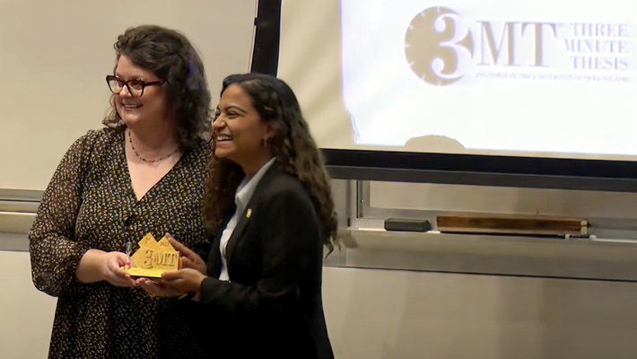 University Librarian Kara Whatley hands award to Niyati Desai