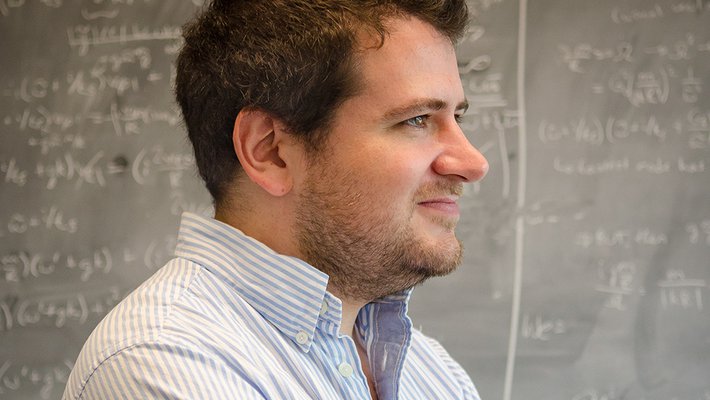 Phil Hopkins standing in front of a chalkboard with equations