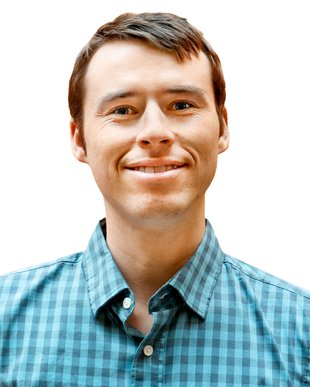 Portrait of Patryk Kozlowski. He wears a checked blue buttoned shirt and has short brown hair.