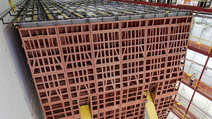 A massive neutrino detector that looks a like a red steel lattice the size of a building.
