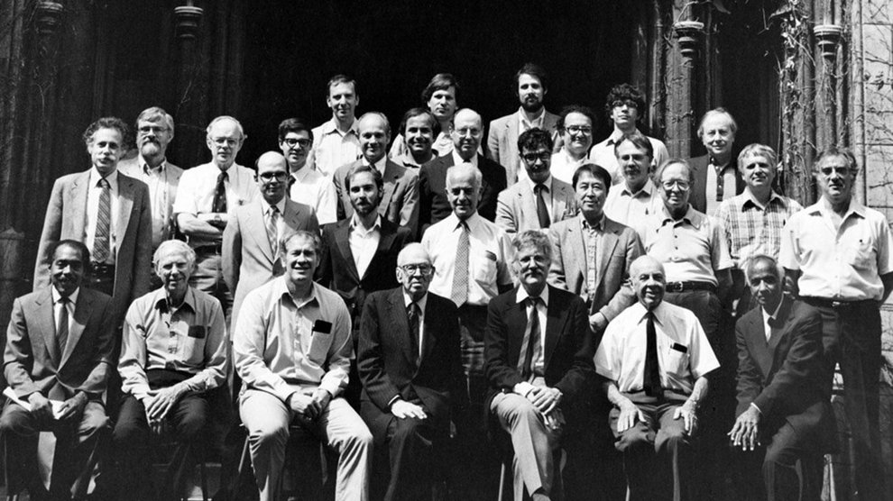 A group of about 30 men, many in jackets and ties, pose for a black and white photo of the physics faculty at the University of Chicago.