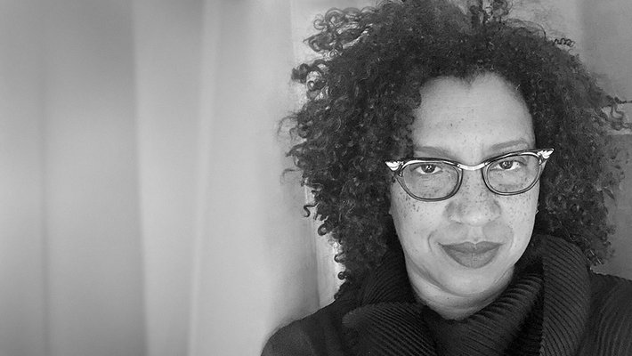 A black and white portrait of Robin Coste Lewis. The image is grainy, as though captured on old film.