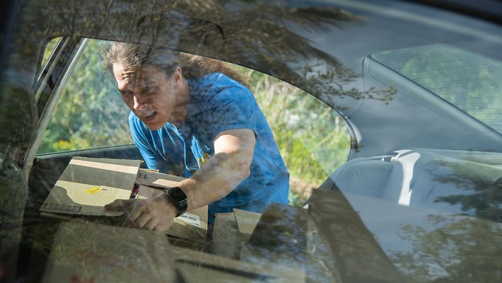 Caltech graduate student Roman Korol loads boxes of humanitarian aid for Ukraine into his car