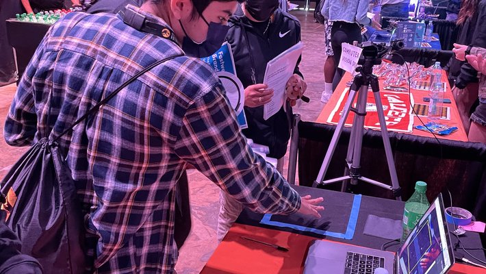 Jeff Ma (BS '22) runs through a computer vision program demo for prospective students at Universal Studios Lot Jurassic Park STEM fair in spring 2022