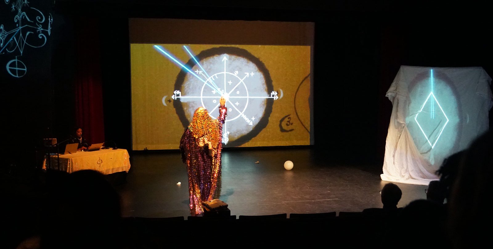 Meena Murugesan (left, behind table) and d. Sabela grimes (center) in "Parable of the Pathmakers"