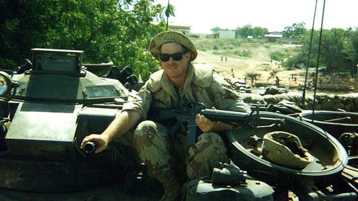 Shane Eagan, an electrician from Caltech's electrical shop, rides atop a vehicle in Mogadishu, Somalia, circa 1993.