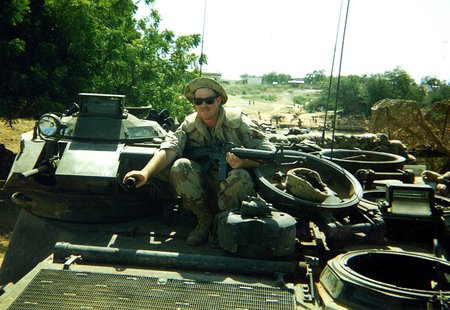 Shane Eagan, an electrician from Caltech's electrical shop, rides atop a vehicle in Mogadishu, Somalia, circa 1993.