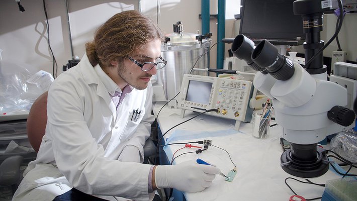 A student engages in research in a lab. 