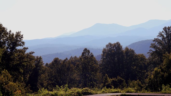 A photo of the Great Smoky Mountains. Forested hills and mountains are seen.
