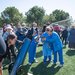 a crowd of people gathered around a solar telescope on an athletic field