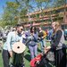 a man on a field setting up a solar telescope on a tripod, surrounded by people gathered to see the solar eclipse