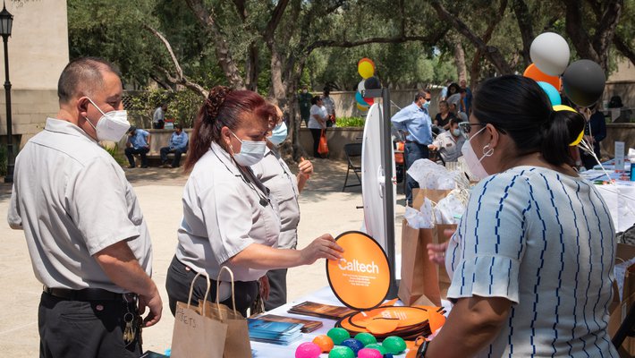 Staff members select items from a gift booth at an event celebrating employees who have been working on campus throughout the pandemic.