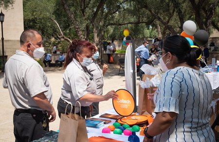 Staff members select items from a gift booth at an event celebrating employees who have been working on campus throughout the pandemic.