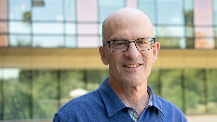 A man with a blue shirt outside of a Caltech building