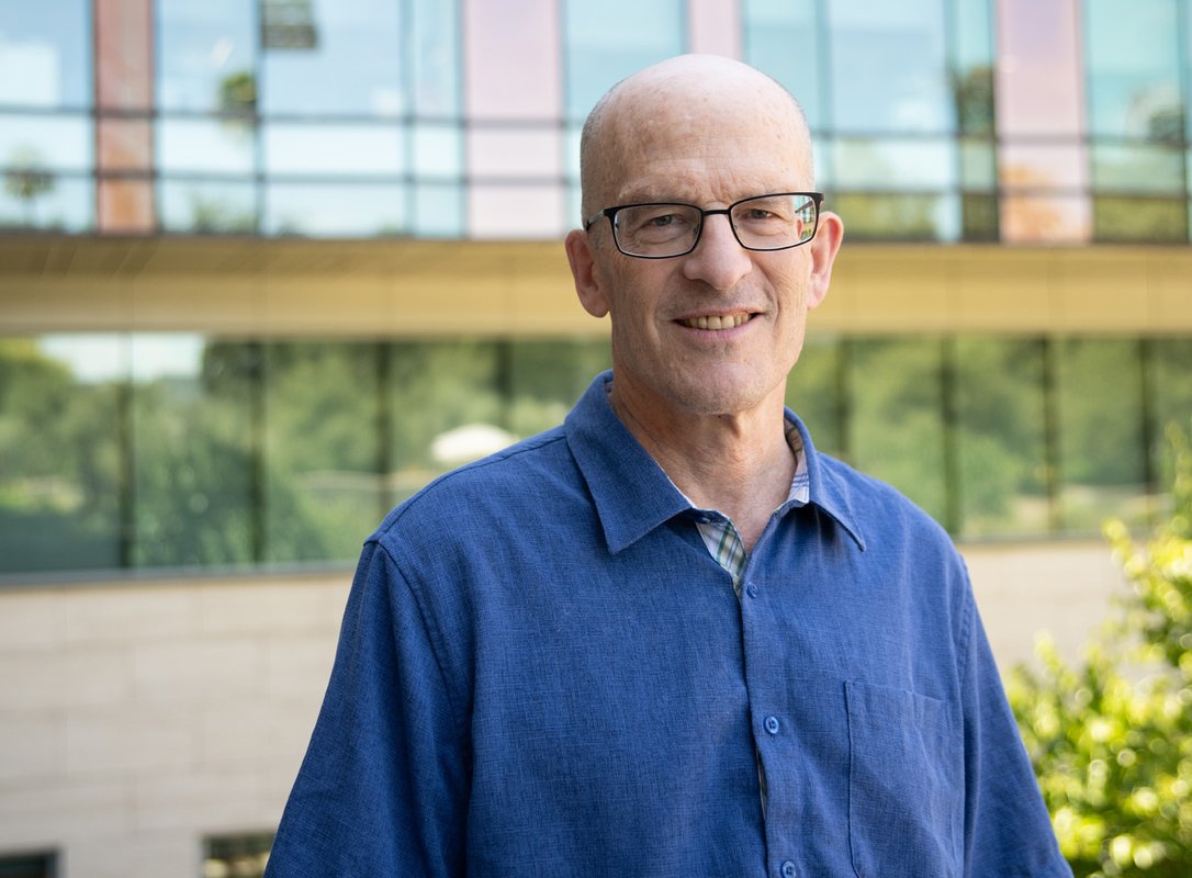 A man with a blue shirt outside of a Caltech building