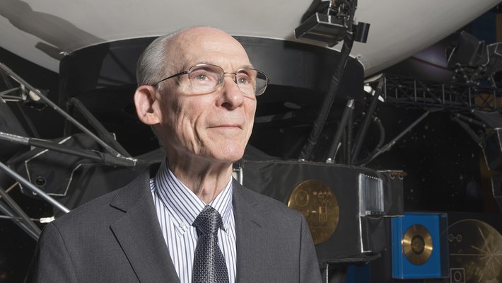 A man standing in front of a large model of a spacecraft