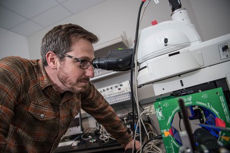 Man looking through microscope.